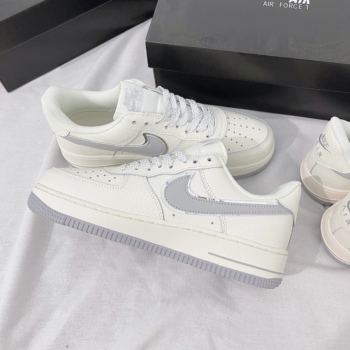 <h4 style="text-align: center;"><strong>The image shows a white Nike Air Force 1 shoe featuring light gray Nike logo details.</strong></h4>